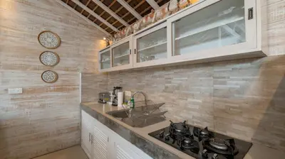 a kitchen with a sink and a stove at Villa Little Mannao by Villa Finder in Kerobokan