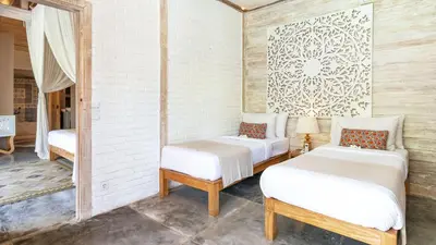 a room with two beds and a mirror at Villa Little Mannao by Villa Finder in Kerobokan