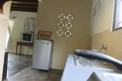 a kitchen with a small refrigerator and a tv at Puri Kutat Lestari in Sanur