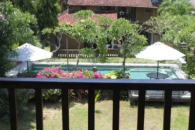 a view from the balcony of a resort with a swimming pool at Puri Kutat Lestari in Sanur