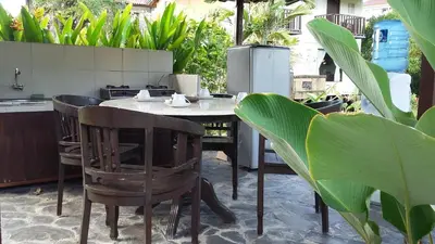 a table and chairs in a kitchen with plants at Puri Kutat Lestari in Sanur