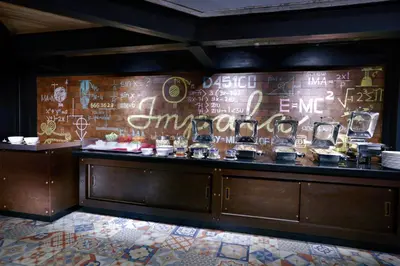 a restaurant with a wall with writing on it at favehotel Kuta Kartika Plaza in Kuta