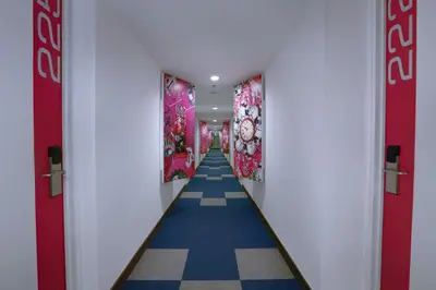 a hallway with red doors and a blue and white floor at favehotel Kuta Kartika Plaza in Kuta