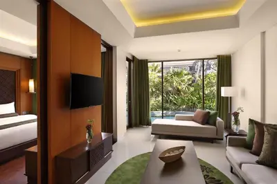 a hotel room with a bed and a living room at Golden Tulip Jineng Resort Bali in Kuta