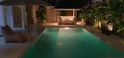 a swimming pool in the middle of a house at night at La Dolce Villa in Seminyak
