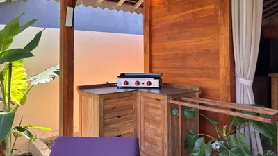 a grill sitting on a stand in a room with plants at Villa Du Bah - Cozy Tropical 3BR Villa 12min To Beach in Kerobokan