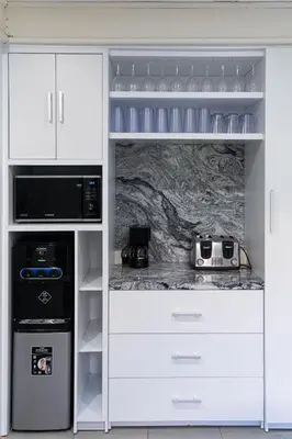 a white kitchen with a stove and a microwave at Villa Kibbi in Seminyak