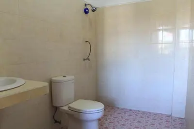 a bathroom with a toilet and a sink at Losmen Cempaka 3 in Kuta