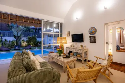 a living room with a couch and a tv at Villa Blue Pearl by Optimum Bali Villas in Seminyak