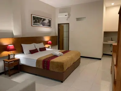 a bedroom with a large bed in a room at Kuta Suci Guesthouse in Kuta
