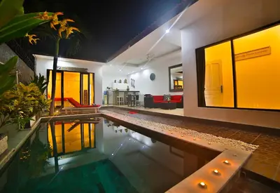 a house with a swimming pool and a living room at Bali Cinta Villa in Seminyak