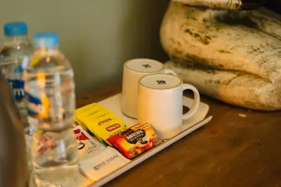 a table with a cup of coffee and a bottle of water at Room Sweet Room - Seminyak Center, walk to the Beach in Seminyak