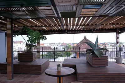 a patio with tables and potted plants on a building at H-ostel Bali in Kuta