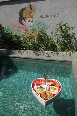 a tray of food in the water in a swimming pool at Sudha Villa Bali Baik-Baik in Seminyak