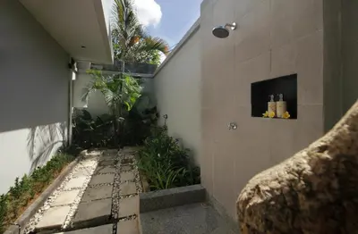 a walkway with plants on the side of a building at Sudha Villa Bali Baik-Baik in Seminyak