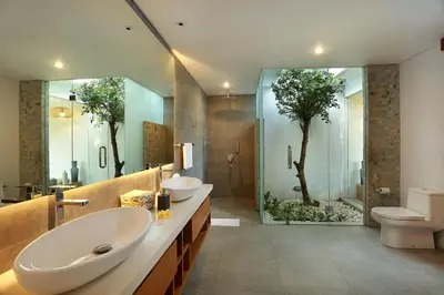 a bathroom with two sinks and a tree in the window at Villa Odyssey in Seminyak