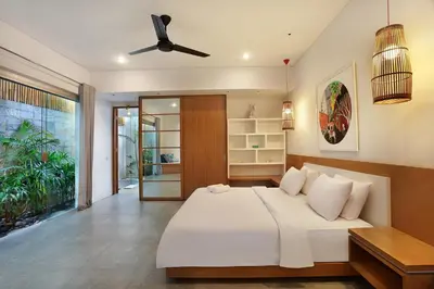 a bedroom with a bed and a ceiling fan at Villa Odyssey in Seminyak