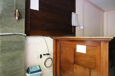 a bathroom with a wooden door and a toilet at Pondok 3 Mertha in Kuta