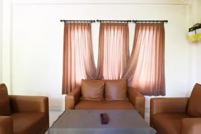 a living room with two couches and a table at Pondok 3 Mertha in Kuta