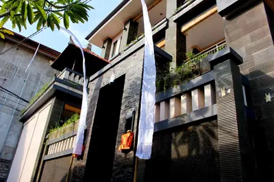 a building with a flag hanging off the side of it at Pondok 3 Mertha in Kuta
