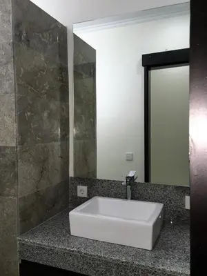 a bathroom with a white sink and a mirror at Indah Homestay in Seminyak