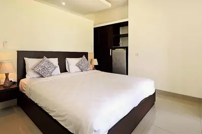 a bedroom with a large bed with two pillows at Indah Homestay in Seminyak