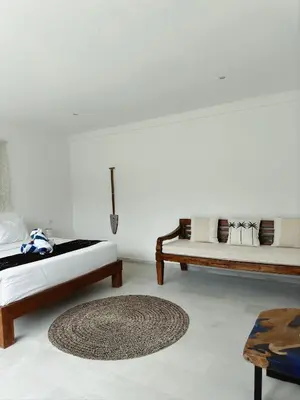 a living room with two beds and a rug at Aster Villa Seminyak in Seminyak