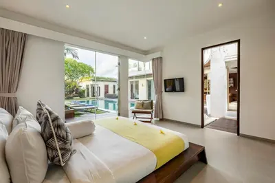 a bedroom with a large bed and a large window at Villa Belle Seminyak by Exotic Bali Properties in Seminyak