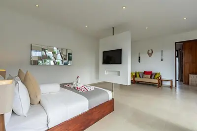a white bedroom with a bed and a living room at Villa Belle Seminyak by Exotic Bali Properties in Seminyak