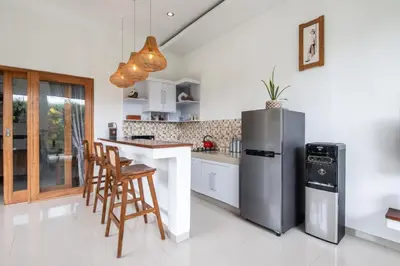 a kitchen with a stainless steel refrigerator and chairs at Adorable 1BR villas in the heart of Seminyak in Seminyak