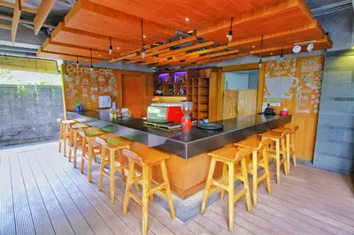 a kitchen with a bar with a bunch of chairs at Swiss-Belexpress Kuta Legian in Kuta