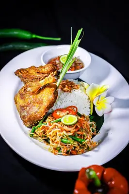 a white plate of food with rice and meat at Swiss-Belexpress Kuta Legian in Kuta