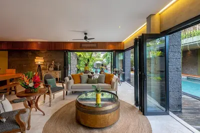 an open living room with a table and a pool at Jadine Bali Villa by Nagisa Bali in Canggu