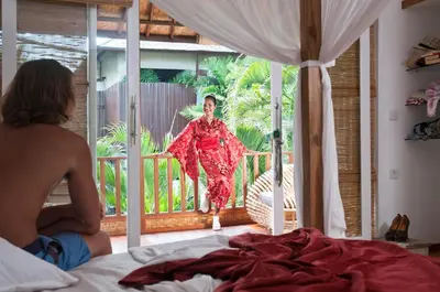 a woman in a red dress standing on a balcony at 3BR Villa Hari - Special Stay Bonus - Minggu Villas Seminyak in Seminyak