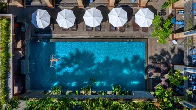 an overhead view of a swimming pool with umbrellas at Solia Legian Bali in Legian
