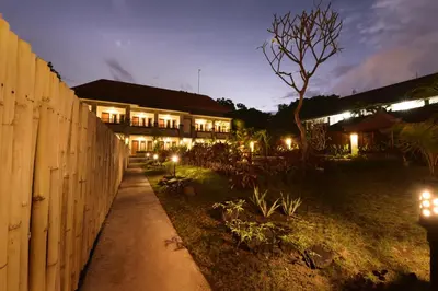 a fence in front of a building at night at Le Lima in Kuta