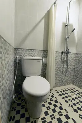 a bathroom with a toilet and a shower at Le Lima in Kuta