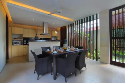 a kitchen and dining room with a table and chairs at The Murdha Villa in Seminyak
