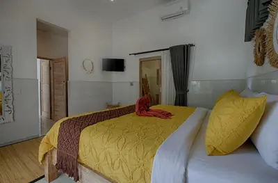 a bedroom with a bed with a red object on it at Pennylane Villa in Seminyak