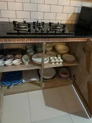 a kitchen with a shelf full of pots and pans at Pennylane Villa in Seminyak