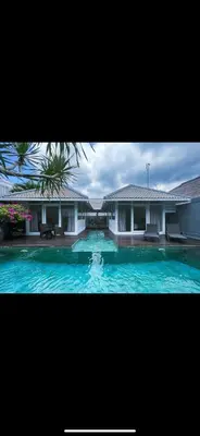 a large swimming pool in front of a house at Villa Giulia in Seminyak