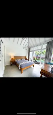 a bedroom with a bed in a room with windows at Villa Giulia in Seminyak