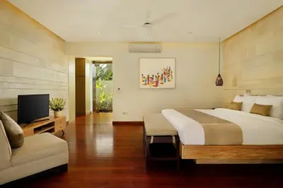 a bedroom with a large bed and a television at Villa Tenang by Nakula in Canggu