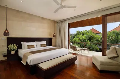 a bedroom with a large bed and a balcony at Villa Tenang by Nakula in Canggu