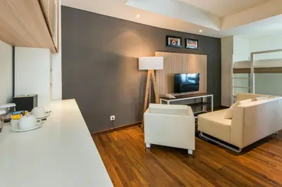 a living room with a couch and a television at Yan's House Hotel in Kuta