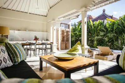 an outdoor living room with a table and chairs at Villa Mandala in Seminyak