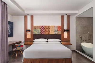 a bedroom with a bed and a tub and a sink at Fairfield by Marriott Bali South Kuta in Kuta