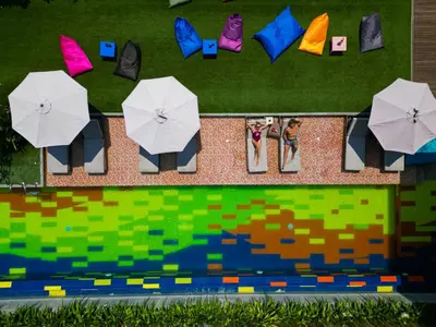an overhead view of chairs with umbrellas next to a pool at Fairfield by Marriott Bali South Kuta in Kuta