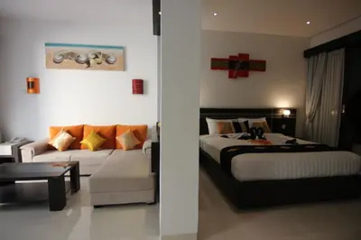 a hotel room with a bed and a couch at The Diana Suite in Kuta