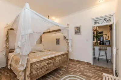 a bedroom with a bed with a mosquito net at Villa Kamboja Younger in Seminyak